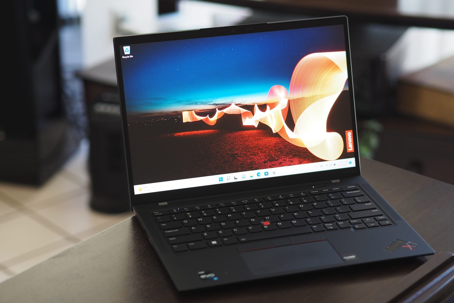 The ThinkPad X1 Carbon Gen 10 laptop, opened with a colorful wallpaper on the screen.