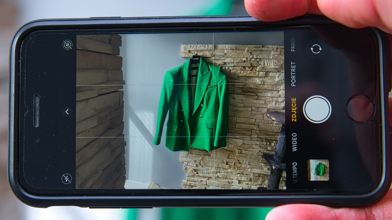 iPhone photo of a green jacket against a brick background