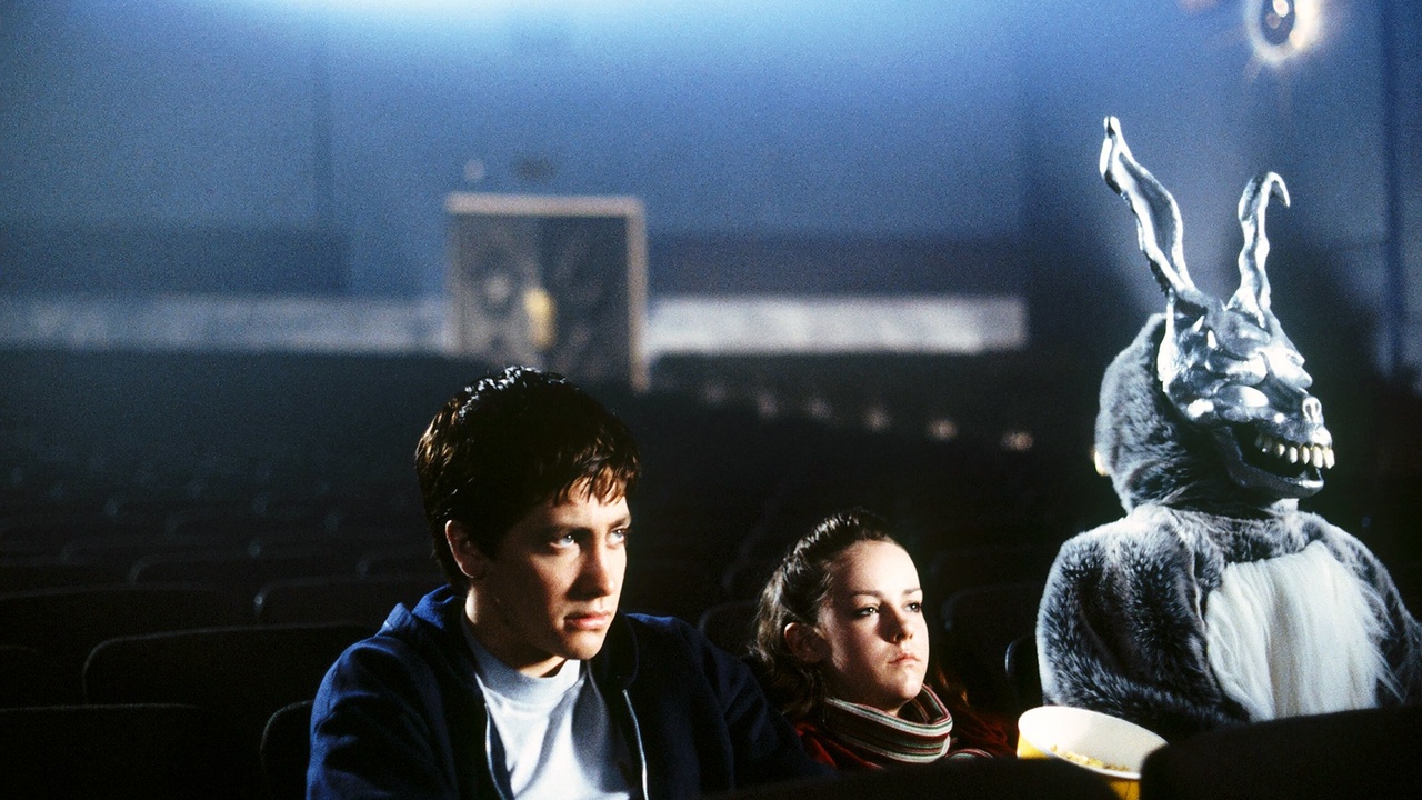 Jake Gyllenhaal and Jena Malone as Donnie and Gretchen at the movies sitting besides a giant rabbit in Donnie Darko.